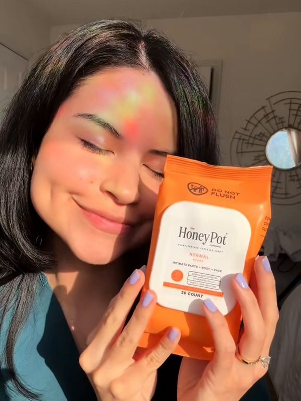 Andrea smiling with a pack of The Honey Pot intimate wipes